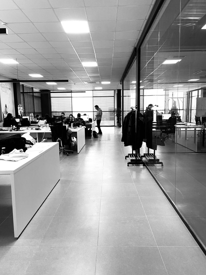 Black and white of anonymous employees working together in modern office with glass walls